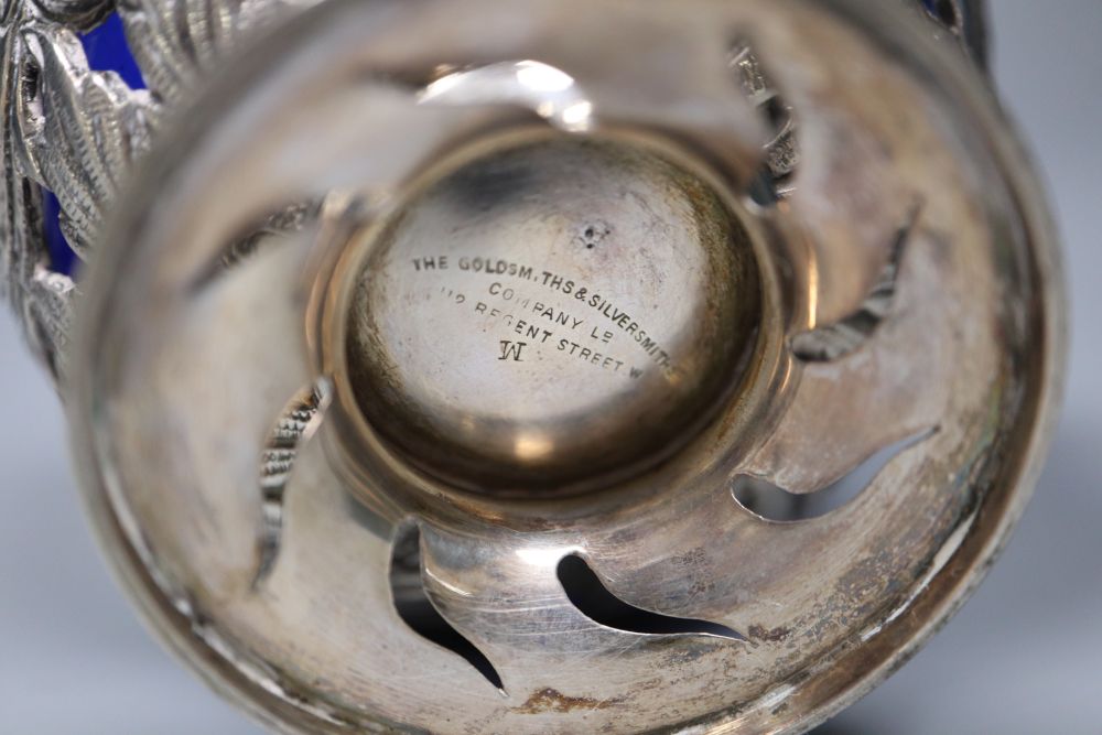 An Edwardian silver sugar basket, George V silver bon-bon dish, silver mounted match strike and a mug salt and spoon (4)